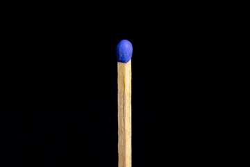 Single blue matchstick in front of black background.