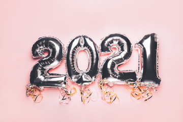 Balloon Bunting for celebration of New Year 2021 made from Silver Number Balloons on pink background. Holiday Party Decoration or postcard concept