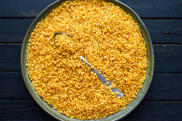Plate with uncooked healthy vegan ingredient bulgur top view