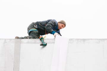 Industrial climber repair billboard. Risky job. Work on height. Metal construction. Electric screwdrive.