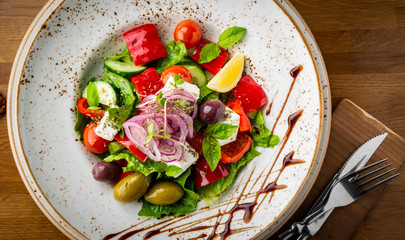 Greek salad with feta cheese, cherry, onion, olives and herbs.