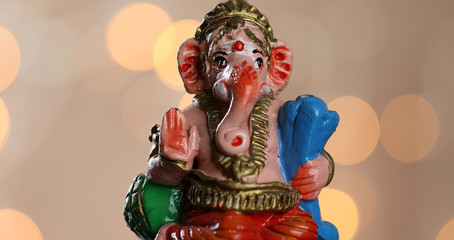 Close up of symbolic and colourful Lord Ganesha on a bokeh lights background