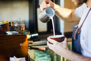 Fototapeta na wymiar barista pouring steamed milk