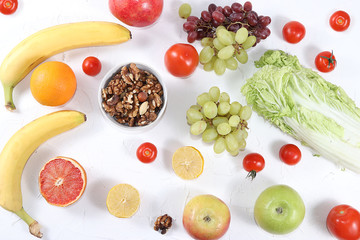 Healthy breakfast, food for children, granola, oranges, banana, pomegranate, tomatoes, cabbage and grapes on a light table. The concept of healthy and natural food, lifestyle. selective focus