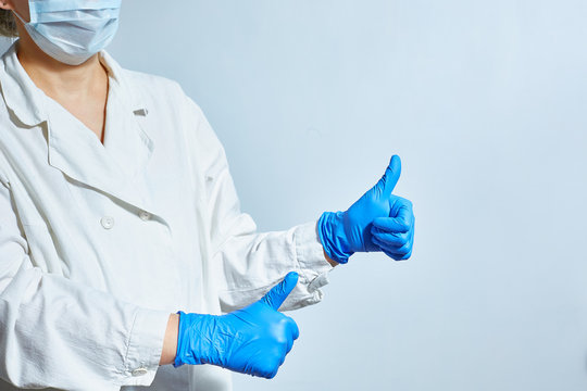 A Nurse In Protective Gloves And A White Doctors Lab Coat In A Face Mask Shows That Everything Is Fine.