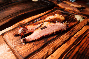 Delicious and juicy slices of fried steak served on a wooden board.
