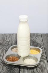 Bottle of milk. On the neck of the bottle is twine with a wax locket. Nearby in the container are...