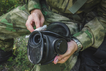 a military man sits and wipes his mask