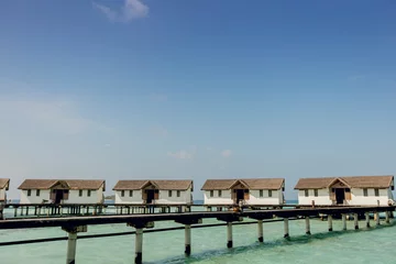 Fotobehang Beautiful beach with water bungalows and long jetty at Maldives. Summer travel holiday concept. © Whiteline