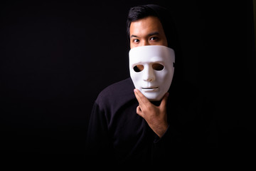 Portrait of young Asian man with hoodie wearing mask