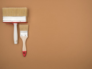 Brush set for painting works. Beige background. Building tool.