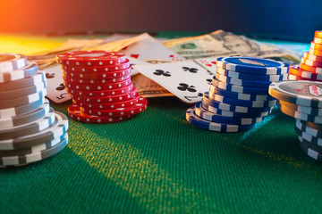 Casino chips on a poker table against the background of cards, money with creative light