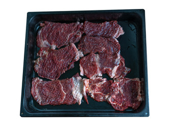 Raw chopped meat on a baking sheet on a white background