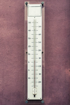 old glass thermometer on pink wall