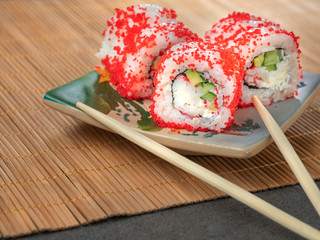 close up view to sushi set with caviar and crab on the plate with chopstick and copy space