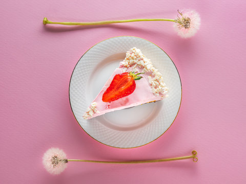 Overhead View To Strawberry Pie On The White Plate Between Two Dandelions On The Pink Background