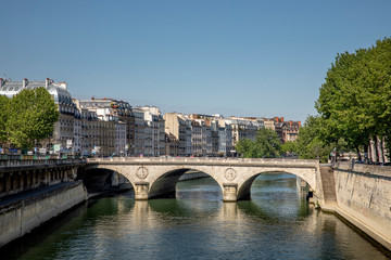 Fototapeta na wymiar Paris, France - May 6, 2020: Typical Haussmann buildings in the left Seine river side in Paris. There is nobody in the street due to lockdown because of covid-19