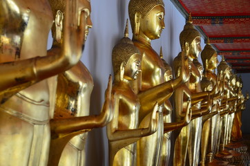 Golden buddha statues standing in a row at Wat Pho, Bangkok