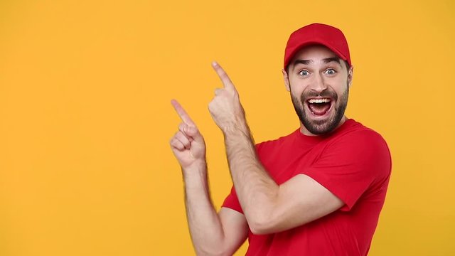Delivery young guy man in red cap blank t-shirt uniform workwear pointing hands on workspace isolated on yellow background studio Professional male deliveryman employee working courier Service concept