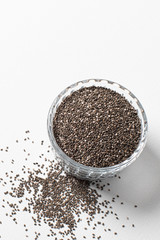 Chia seeds in a cup beautifully laid out on a white background. copy space. Vegetarian food.