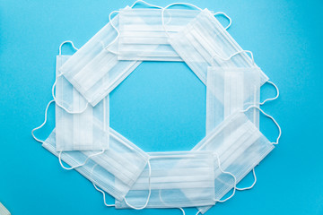 Polygon of White protective medical masks on a blue background in the center