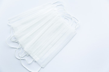 Several white protective medical masks on a white background on the left. Empty white background on the right. Personal protective equipment