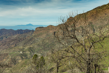 Aerial view of the center of Gran Canaria. Famous Bentayga rock in huge caldera and the island of Tenerife with beautifull volcano Teide above the horizon