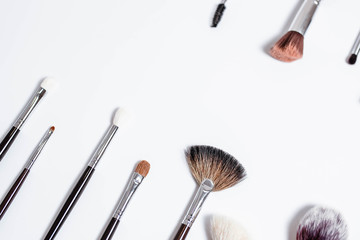 Flat top view a set of professional makeup brushes on a light background. Copy space for your text. Make-up brushe over white background. Aerial view of various brushes. Various makeup brush sizes.