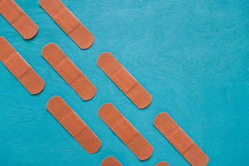 Angled Rows of Adhesive Bandages on Turquoise Background