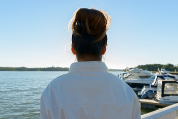 Closeup rear view of young Asian woman against beautiful scenery at the pier