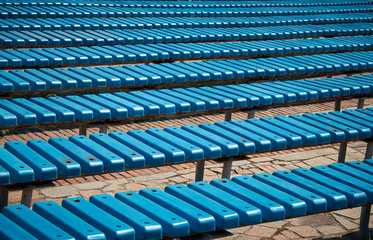 Obraz premium Pattern of blue plastic benches. Striped benches in daylight. Concert venues in front of the crowd.