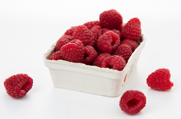 
Fresh raspberries in a cardboard box on a white background