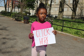 Kid holding Click Here sign outside