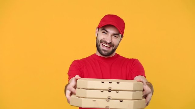Delivery guy man in red cap t-shirt uniform workwear hold give order empty cardboard pizza boxes takeaway isolated on yellow background studio Professional male employee work courier Service concept