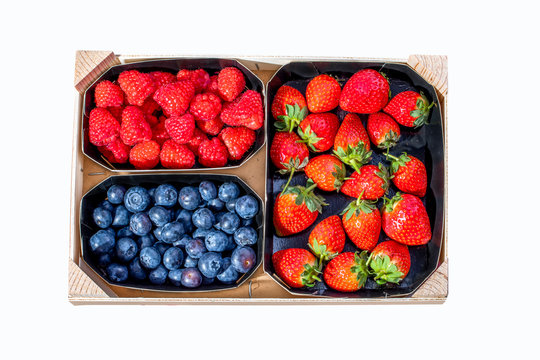 Fresh bluberries, raspberries and strawberries in a wooden box. Top view