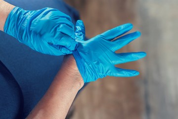 A woman's hand in blue rubber gloves, above vantage point photography, close up