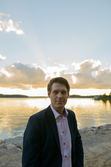 Young handsome businessman in front of beautiful scenic shore