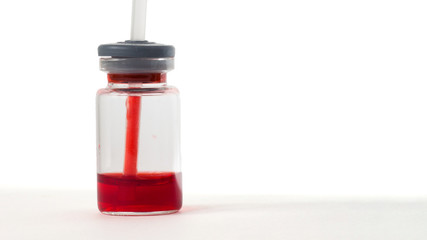 Bottle with a bright red liquid on a white background. The medicine is red. Antibodies against the virus.