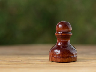 Pawn, the weakest chess piece. The material of the pawn is varnished wood.