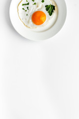Fried egg on plate on white table top view copy space