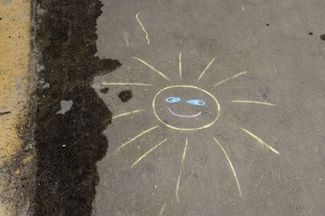 chalk drawing of sun at asphalt