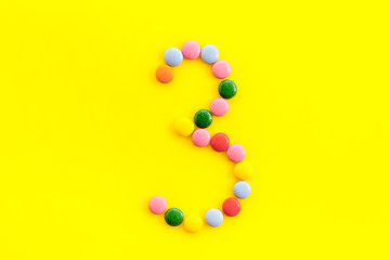 Candies font. Number 3 - three - on yellow background top view