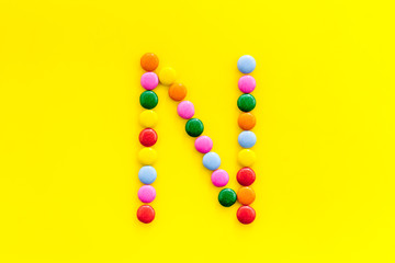 Letter N - alphabet made with sweets on yellow from above