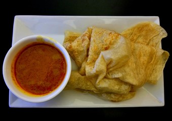 Malaysian pancake, also known as roti canai, with a side of curry gravy