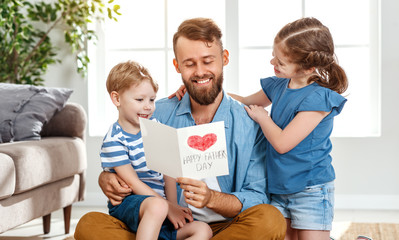Happy father receiving greeting card from kids.