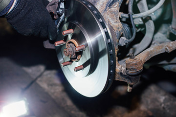 installation of a ventilated brake disc of a car on a hub in a garage. brake system repair