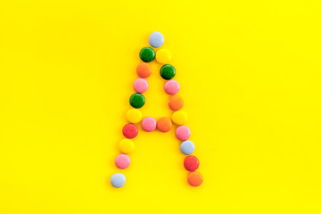 Letter A - alphabet made with sweets on yellow from above