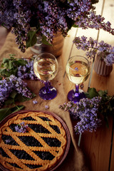 Pie and glasses surrounded by lilacs