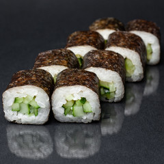 diverse delicious sushi roll set on a black background with reflection, menu