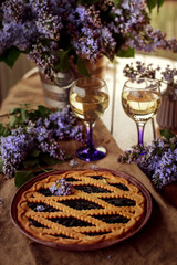 Pie and glasses surrounded by lilacs